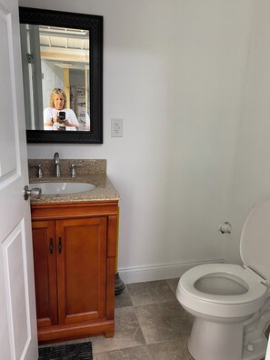 Ein Badezimmer mit Waschbecken, Spiegel und Toilette.