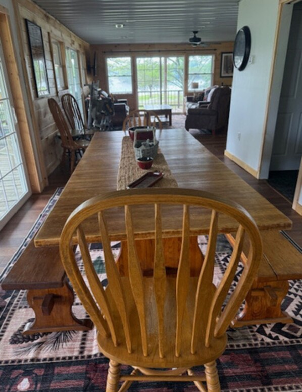 A long wooden dining table with chairs, a bench, and a rug.