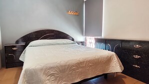 Un dormitorio con cama, cómoda y mesita de noche.