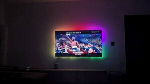 Et fjernsyn hængt på væggen der viser en sportsbegivenhed.