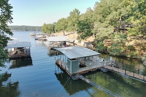Une série de quais flottants, reliés à des structures, probablement destinées à l’amarrage de bateaux, entourés d’une étendue d’eau calme et d’une végétation dense.