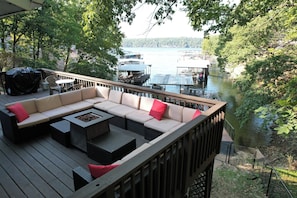 Une terrasse avec un canapé, des tables et un barbecue.