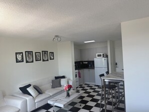 Eine moderne Wohnung mit Wohnzimmer, Küche und Essbereich.