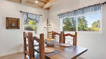 Un coin repas avec une table en bois, des chaises et un lustre.