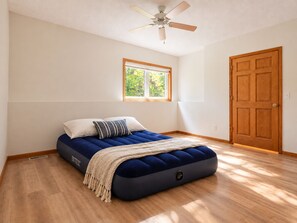 A bedroom with a bed, a ceiling fan, a window, and a door. - Stay in Woodbury, Minnesota. Comfort & Convenience (Woodbury)