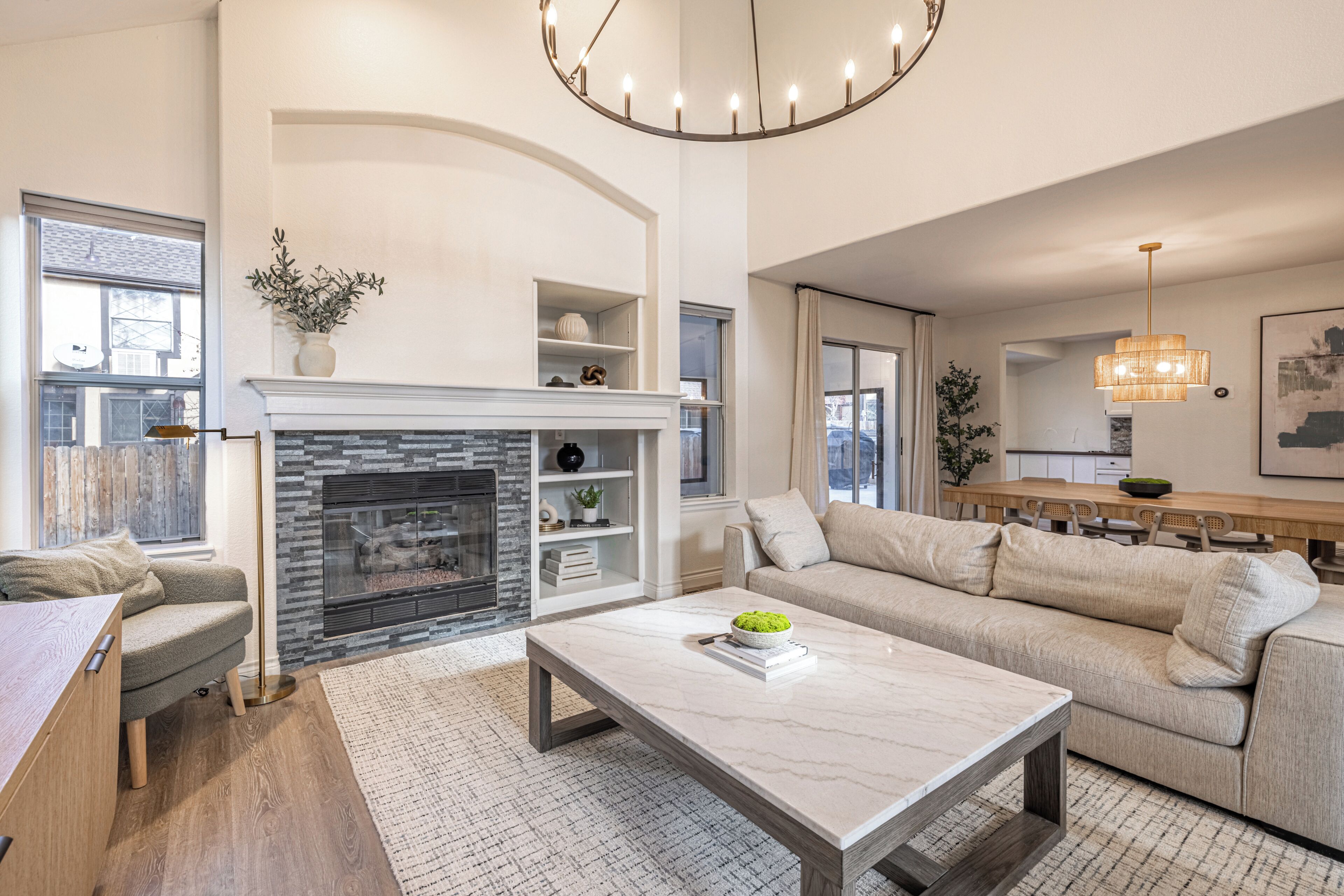 Uma sala de estar moderna com lareira, um sofá, uma mesa de centro e um espaço de refeições.