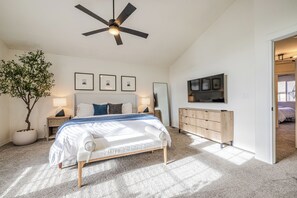 A bedroom with a bed, a ceiling fan, a dresser, a TV, and a potted plant. - Spacious 4BR Aurora Home with Sunroom and Fireplace (Aurora)