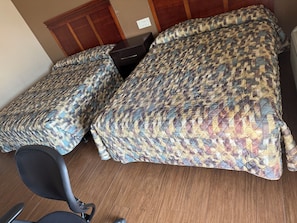 Una habitación de hotel con dos camas, un escritorio y una silla.