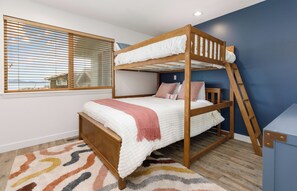 A bunk bed room with a window, a patterned rug, and a desk. - Whidbey Island Updated Beachfront Getaway - A View From Every Room! (Oak Harbor)
