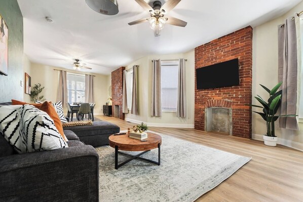 A living room with a sofa, coffee table, and a fireplace. - Games+Netflix+BBQ+FREE Parking Near Bakery Square (Pittsburgh)