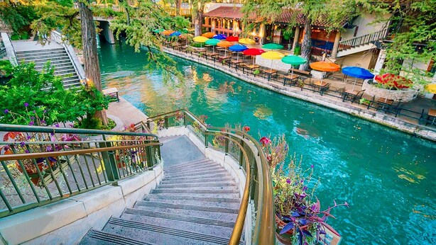 A riverside walkway with outdoor seating and a staircase leading down to the water. -     Luxury River Walk Retreat 2BR Downtown (San Antonio)