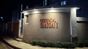 En bygning med et skilt, der står 'RESIDENCIAL SWADDAI I', om natten.
