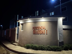 Un immeuble avec une enseigne indiquant « RESIDENCIAL SWADDAI I », de nuit.