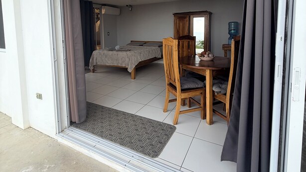 Ein Zimmer mit einem Bett, einem Tisch mit Stühlen und einem Wasserspender.