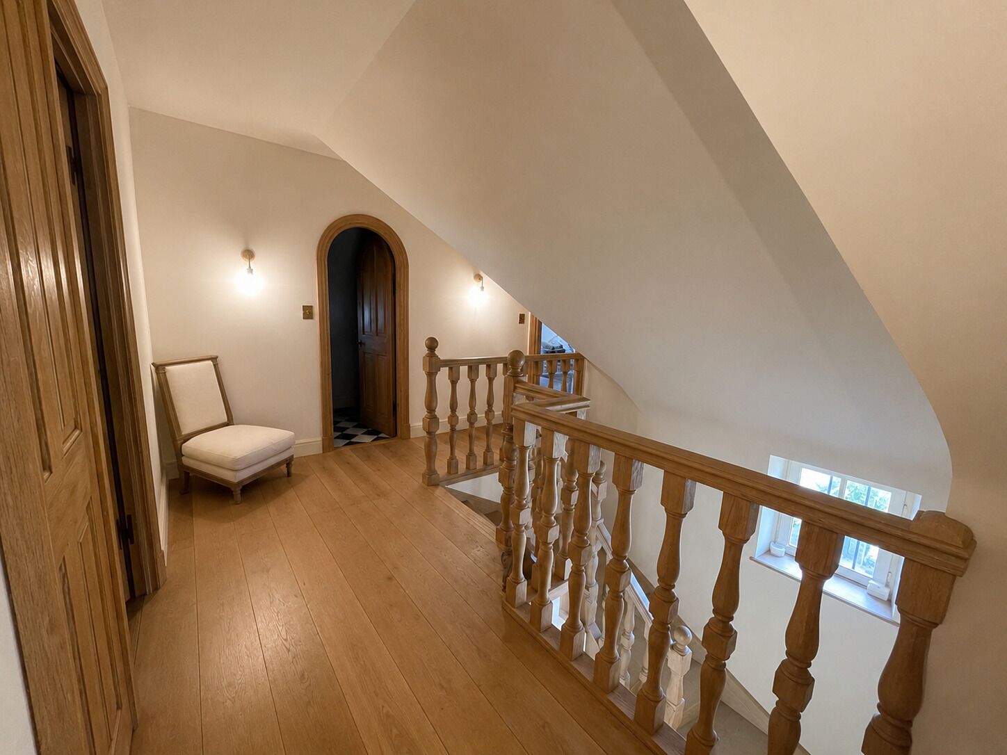 A wooden staircase with a balustrade leading to an upper floor.