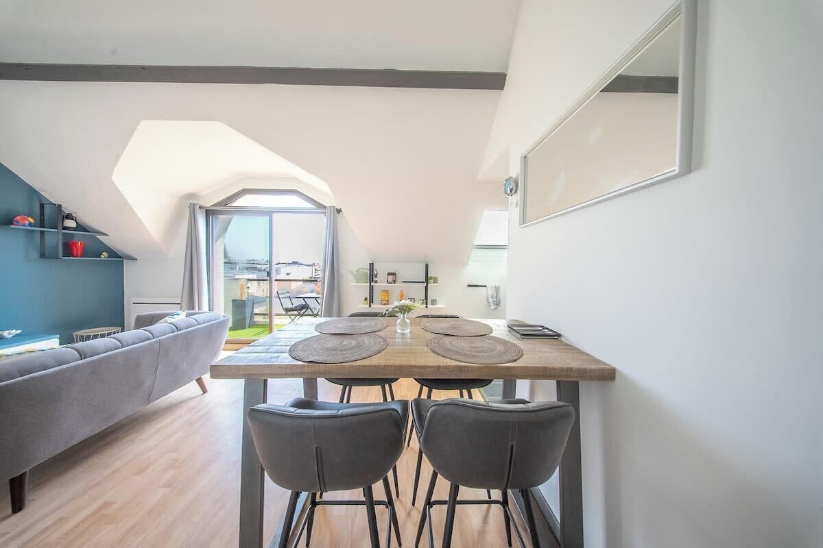 Ein stilvoller Essbereich mit Holztisch, vier Stühlen und Blick durch eine Glastür in einen Außenbereich.