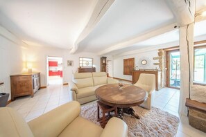 Ein geräumiges Wohnzimmer mit einem runden Holztisch, einem beigen Sofa und einem flauschigen Teppich.