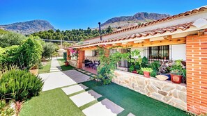 A residential property with a patio, potted plants, and a view of mountains.