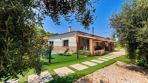 A residential property with a fenced yard, a swimming pool, and a pathway leading to the house.