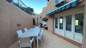A patio with a table and chairs, a sliding glass door, and an air conditioning unit. - Villa Los Arcos Turre by Ruralidays (Almería)