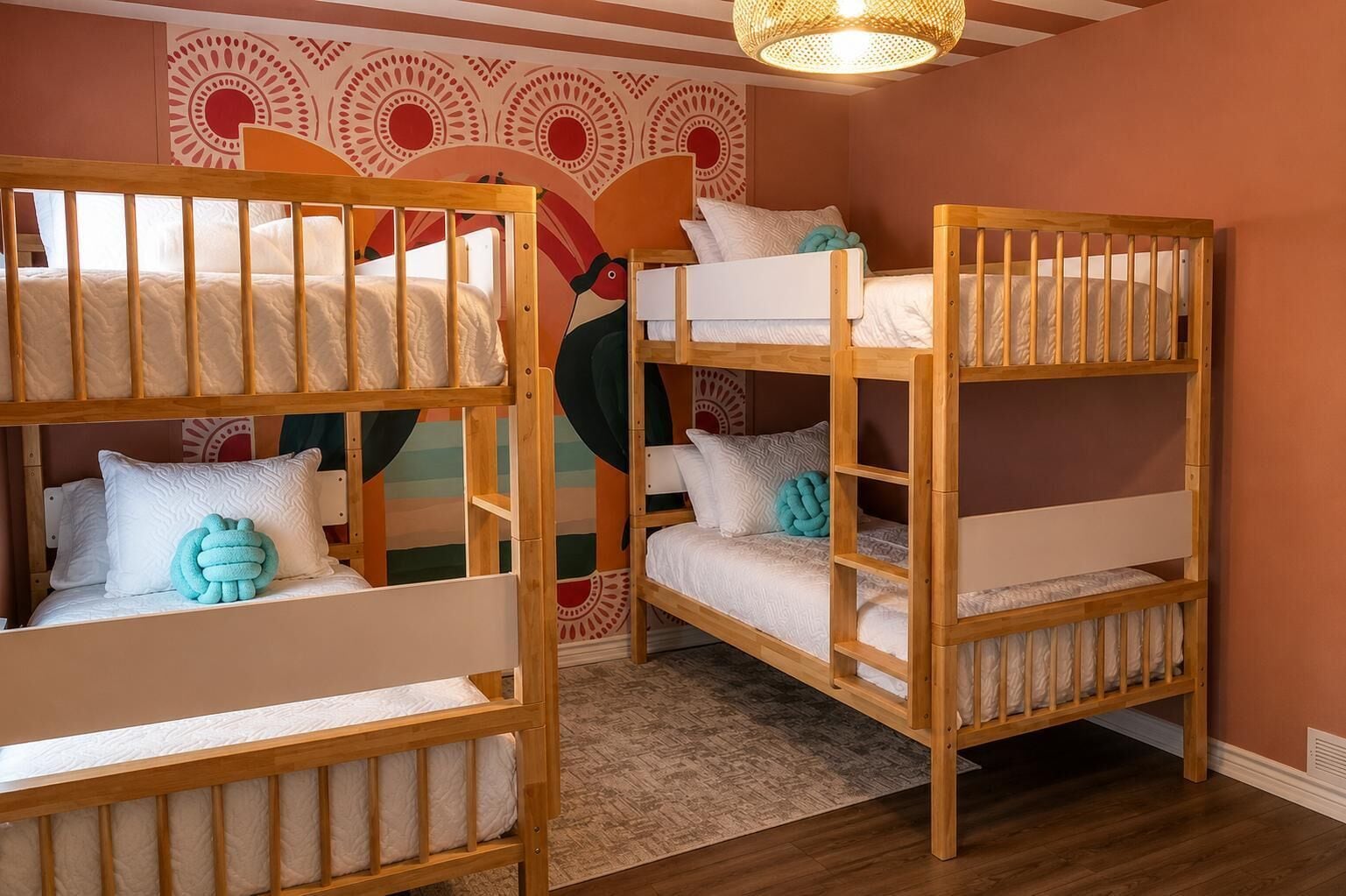 Een kamer met twee stapelbedden, een behang met patroon en een geweven lamp.