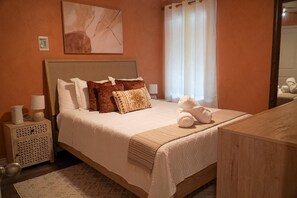 Una camera d'albergo con un letto, comodini, uno specchio e una finestra con tende.