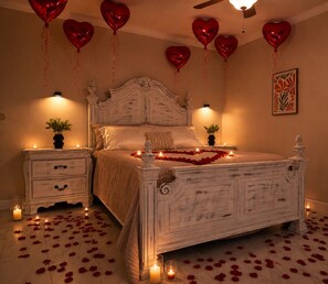 A bedroom with a bed, bedside tables, and decorative elements like candles and heart-shaped balloons. - Family Nest Romantic Stay-Memories (Bradenton)