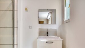 A bathroom with a white sink, a mirror above it, and a towel on the sink. - Le Devillois - 4 chambres, balcon et garage près de Rouen (Déville-lès-Rouen)