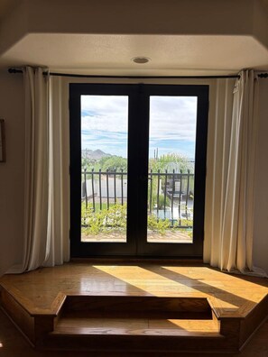 A room with a large sliding glass door leading to a balcony with a view of a mountainous landscape. - New- Apache Junction, Amazing View, Hiking, Golf (Apache Junction)