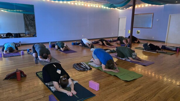 A yoga class in a room with wooden floors, mats, and a mirror on one wall. - Desert Estate at the Base of the Superstition Mountains (Apache Junction)