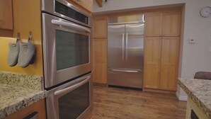 A kitchen with stainless steel appliances, wooden cabinets, and granite countertops. - 3-bedroom house in charming Burbank with cool AC (Burbank)