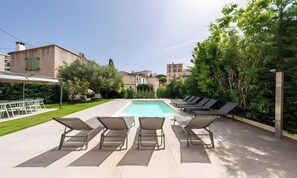 A rectangular swimming pool with lounge chairs facing it, surrounded by a paved patio area. - POOL FRENCH VILLA WITH GYM , SAUNA - IN THE HEART OF CANNES- 250 SQM (Cannes)