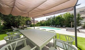 A covered outdoor area with a pool, lounge chairs, and a dining table with chairs. - POOL FRENCH VILLA WITH GYM , SAUNA - IN THE HEART OF CANNES- 250 SQM (Cannes)