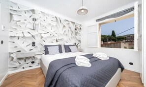 A bedroom with a bed, a window, and a wall with a leaf-like pattern. - POOL FRENCH VILLA WITH GYM , SAUNA - IN THE HEART OF CANNES- 250 SQM (Cannes)