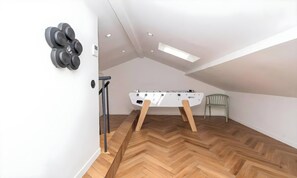 A room with a foosball table, a chair, and a set of dumbbells on the wall. - POOL FRENCH VILLA WITH GYM , SAUNA - IN THE HEART OF CANNES- 250 SQM (Cannes)