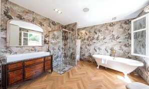 A bathroom with a wooden herringbone floor, a freestanding bathtub, a glass-enclosed shower, and a large mirror above the vanity. - POOL FRENCH VILLA WITH GYM , SAUNA - IN THE HEART OF CANNES- 250 SQM (Cannes)