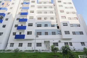 A multi-story building with balconies, a gated entrance, and a clear sky. - Tanger Élégance Smart Stay WIFI & Netflix (Tanger)