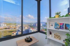 A room with a large window, a wooden shelf with books, a decorative sign, and a small table with a tray. - Tanger Élégance Smart Stay WIFI & Netflix (Tanger)