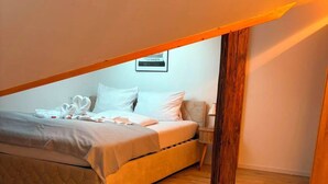 A bedroom with a bed, a nightstand, and a wall-mounted light fixture. - Eibisch Apartments (Passau)