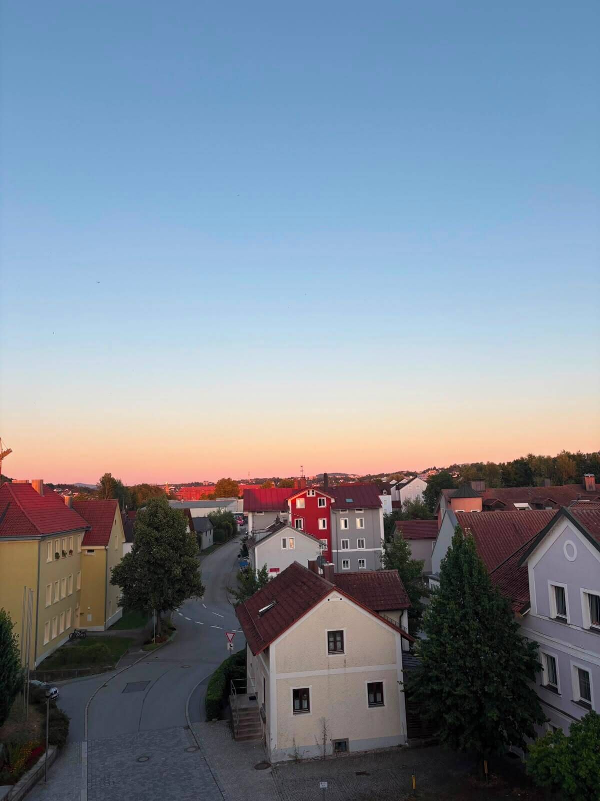A residential area with buildings, a street, and a clear sky.