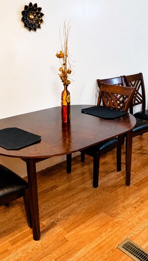 A dining table with chairs, a vase with dried flowers, and a decorative wall piece. - 2-bedroom mobile home in fantastic Hartwell with free space for boat rv parking  (Hartwell)