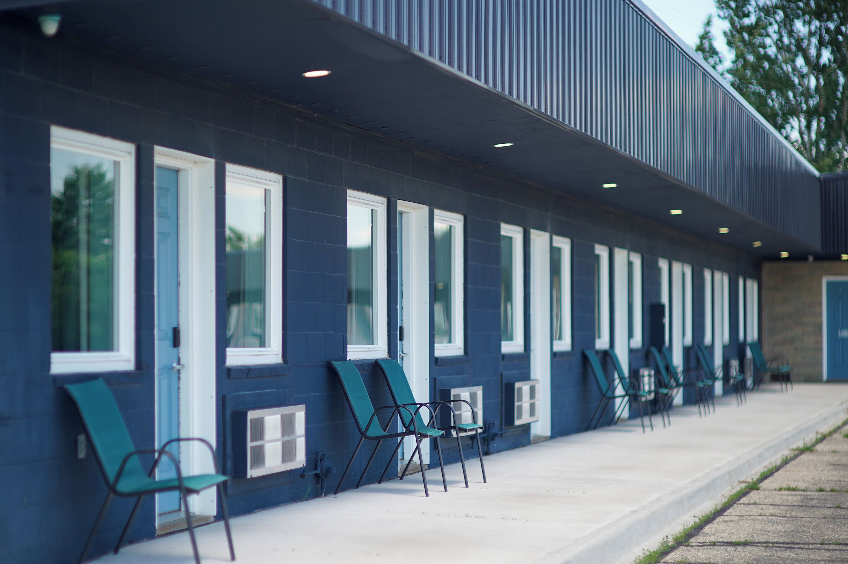 A building with a row of windows and outdoor seating.