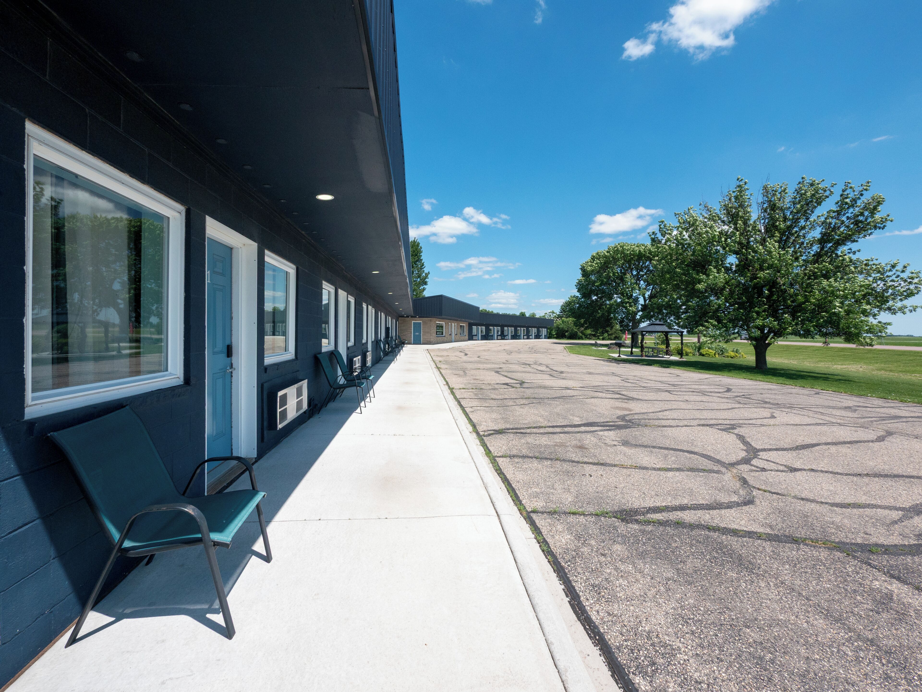 A building with a row of windows and a covered outdoor seating area.