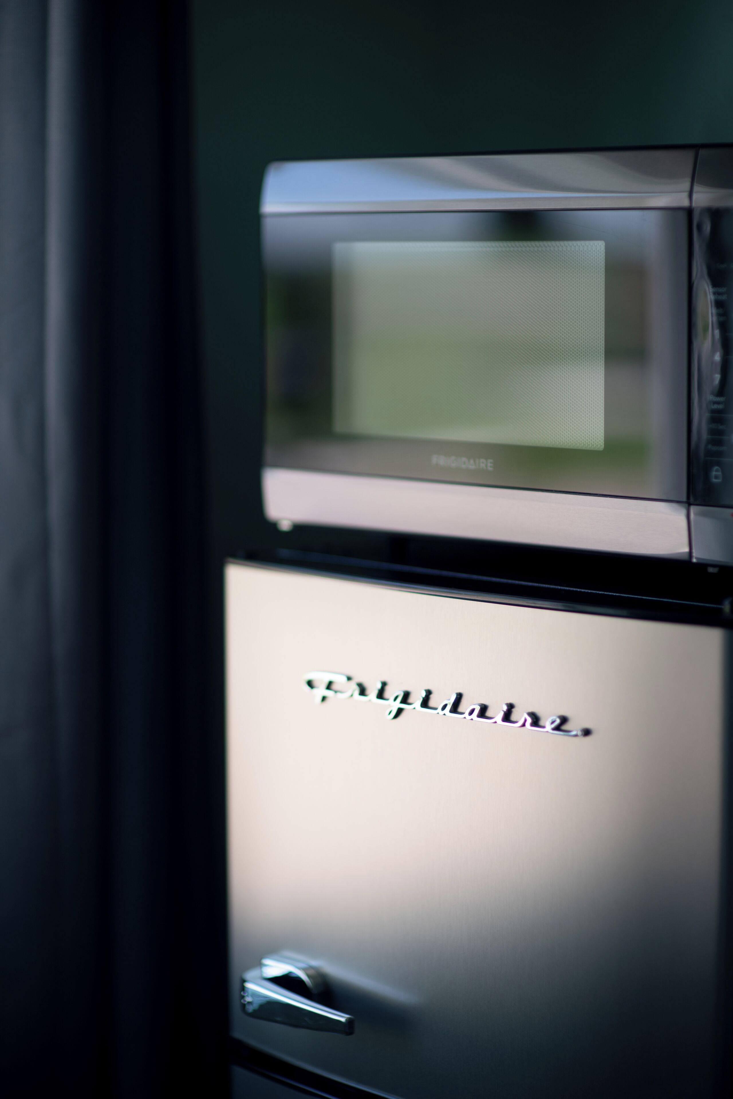 A microwave and a refrigerator with the brand name 'Frigidaire' visible on the refrigerator.