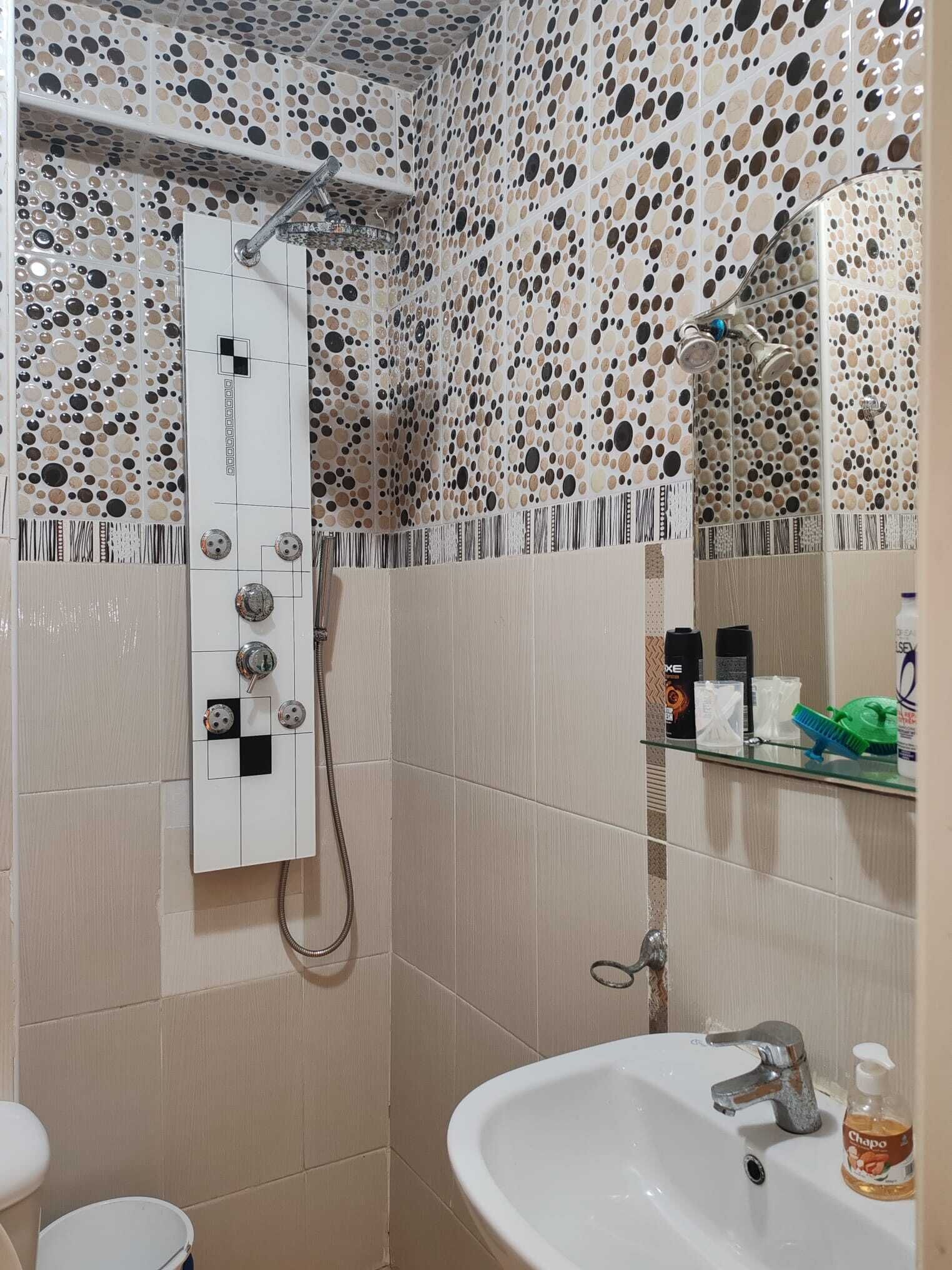 Ein Badezimmer mit Dusche, Waschbecken und Pflegeprodukten.