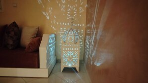 A room with a sofa, a patterned wall, and a decorative light fixture.