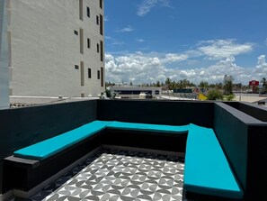 A rooftop terrace with a curved seating area and a patterned floor. - Escápate a Boca de Mar, a pasos de la playa. (Mazatlán)