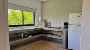 Una cuina compacta amb un rentaplat, microones, cafetera i nevera.