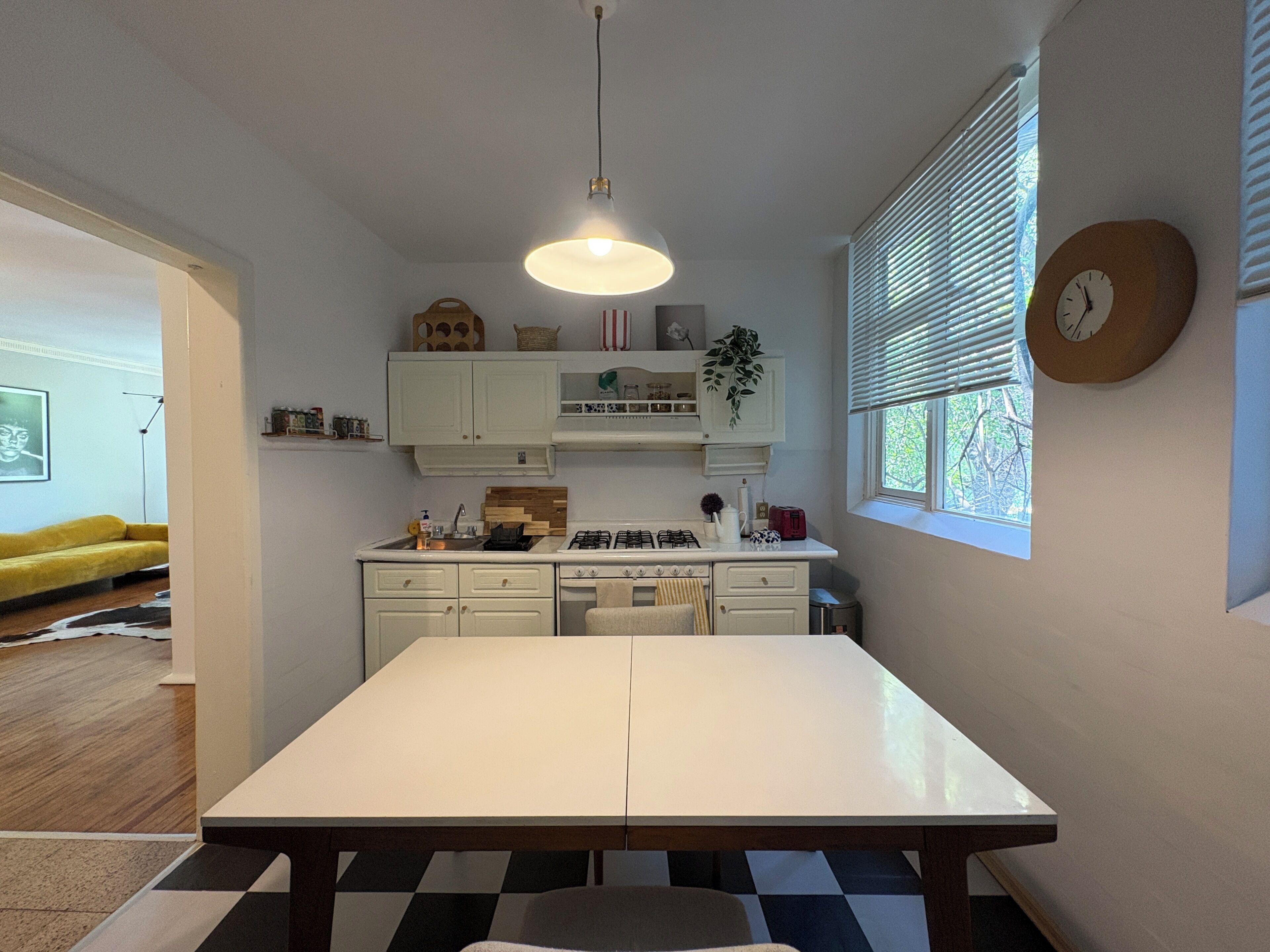 Una cocina moderna con muebles blancos, una isla central y una mesa de comedor.