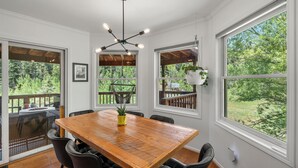 A dining area with a wooden table, black chairs, and a hanging light fixture. - Modern Mountain Retreat - 4-bedroom, family friendly, peaceful (Durango)